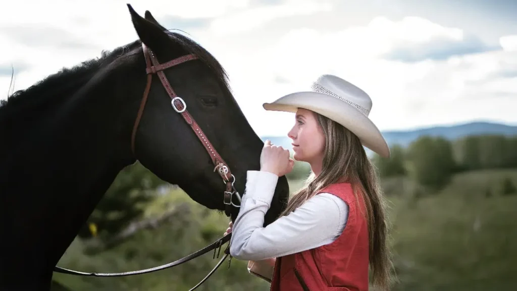 Amber Marshall standing beside her horse on the ranch, reflecting her real-life connection with animals and her Heartland character, Amy Fleming.