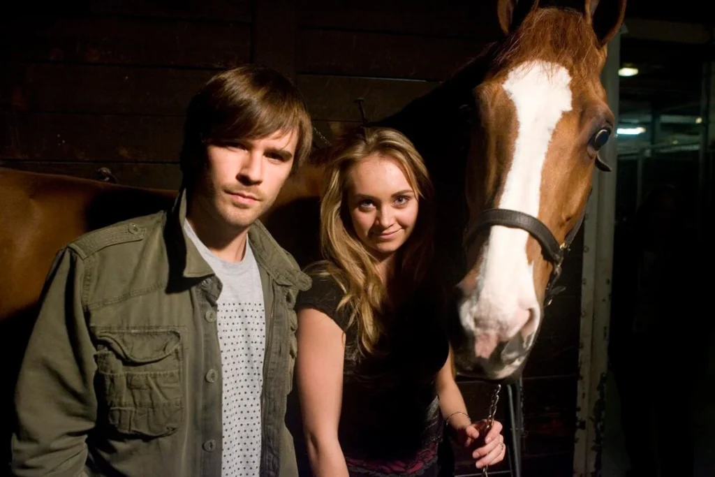 Amy Fleming and Ty Borden with a horse in the Heartland barn