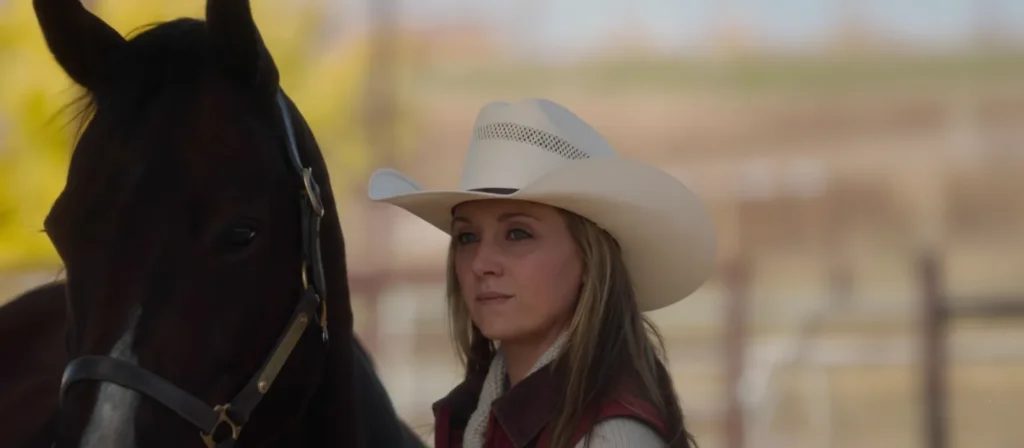 Amy Fleming standing beside a horse at Heartland ranch, calm and focused expression