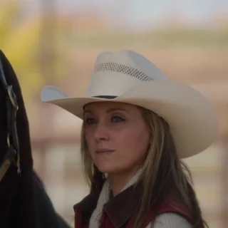 Amy Fleming standing beside a horse at Heartland ranch, calm and focused expression